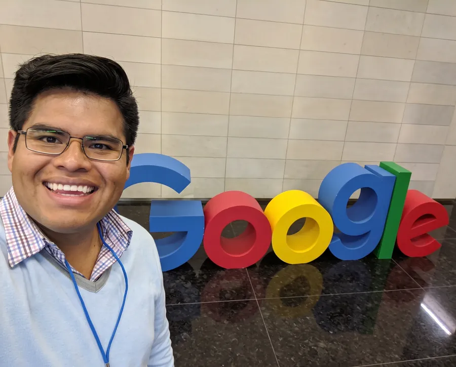 John Chávez junto al logotipo de Google en sus oficinas