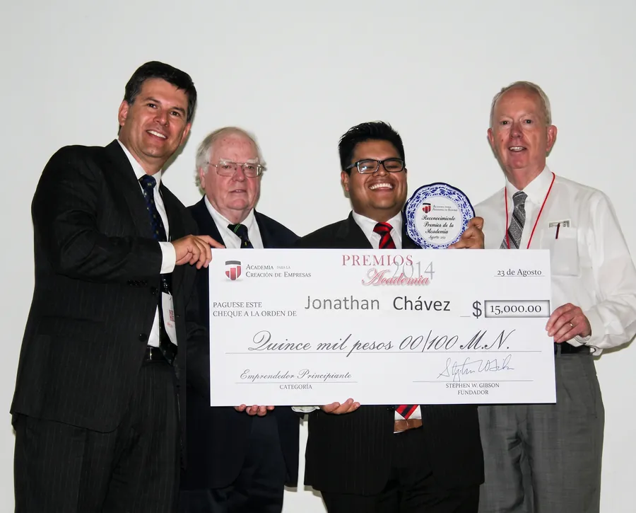 John Chávez recibiendo un premio y un cheque de la Academia para la Creación de Empresas